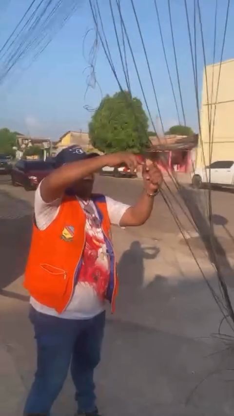 Agente da Prefeitura corta fios baixados na calçada